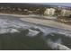 Expansive aerial view showcasing ocean waves, sandy beach, and luxury condo buildings along the coast at 490 Ocean Creek Dr. # 8, Myrtle Beach, SC 29572