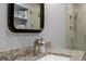 A close-up of a granite vanity with a large mirror, faucet, and decor at 490 Ocean Creek Dr. # 8, Myrtle Beach, SC 29572