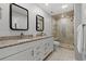 Updated bathroom featuring a double sink vanity and a walk-in tiled shower with glass door at 490 Ocean Creek Dr. # 8, Myrtle Beach, SC 29572