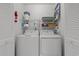 A practical laundry room with a side-by-side washer and dryer, and storage shelves above at 490 Ocean Creek Dr. # 8, Myrtle Beach, SC 29572