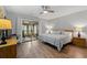 A stylish bedroom featuring a king-size bed, ceiling fan, and access to a bright sunroom at 490 Ocean Creek Dr. # 8, Myrtle Beach, SC 29572