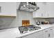 Cooktop features modern stainless steel hood and herringbone backsplash, adding style and functionality to cooking space at 500 Canborough Lane, Murrells Inlet, SC 29576