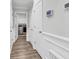 Hallway with wood-look flooring and paneled walls, leading to laundry room and other rooms at 500 Canborough Lane, Murrells Inlet, SC 29576