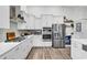 Modern kitchen features stainless steel appliances, white cabinets, and wood-look flooring, a chef's dream space at 500 Canborough Lane, Murrells Inlet, SC 29576