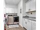 Bright laundry room boasts modern washer/dryer, granite counters, ample white cabinetry, and wood-look flooring at 500 Canborough Lane, Murrells Inlet, SC 29576