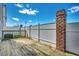 Back deck view with wood flooring, white fence, and brick column detail at 504 Lake Shore Dr., Surfside Beach, SC 29575