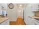 Clean kitchen with white cabinets, modern appliances, and sleek hardwood flooring, leading to other rooms at 5042 Forsythia Circle # 5042, Murrells Inlet, SC 29576