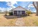Charming single story home featuring a screened porch and landscaped front yard on a sunny day at 5092 Harrelson Ave., Loris, SC 29569