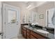 Bathroom with granite countertop, double sinks, a mirror, and a door leading to the outside at 518 Heartland Ct., Murrells Inlet, SC 29576