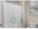 Clean bathroom with a floral shower curtain, toilet, and a window at 518 Heartland Ct., Murrells Inlet, SC 29576