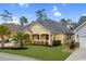 Charming yellow home with a covered porch, white railing, and well-manicured front yard at 518 Heartland Ct., Murrells Inlet, SC 29576