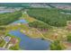 Aerial view of a golf course with lush greenery, water hazards, and surrounding trees at 518 Heartland Ct., Murrells Inlet, SC 29576