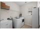 Bright laundry room with white washer and dryer, utility sink, and storage at 518 Heartland Ct., Murrells Inlet, SC 29576