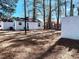 Large backyard featuring a white storage building and a second house, with mature shade trees at 530 Yarboro St., Mullins, SC 29574