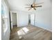 Bedroom with wood-look flooring, ceiling fan, and a view of the en suite bathroom at 530 Yarboro St., Mullins, SC 29574