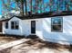 Charming renovated single-story home with a classic black and white exterior design, and tree-lined background at 530 Yarboro St., Mullins, SC 29574