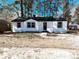 Charming renovated single-story home with a classic black and white exterior design, and tree-lined background at 530 Yarboro St., Mullins, SC 29574