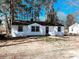 Charming renovated single-story home with a classic black and white exterior design, and tree-lined background at 530 Yarboro St., Mullins, SC 29574