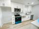 The kitchen features stainless steel appliances, white cabinetry, and hardwood floors at 530 Yarboro St., Mullins, SC 29574