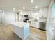 Modern white kitchen featuring a central island, stainless steel appliances, and contemporary fixtures at 530 Yarboro St., Mullins, SC 29574