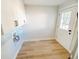 Bright laundry room with white cabinets, hookups, light wood-look floors, and white door to exterior at 530 Yarboro St., Mullins, SC 29574