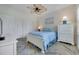 Bright bedroom featuring a white bed with blue comforter, ceiling fan, and white floors at 5801 Oyster Catcher Dr. # 1614, North Myrtle Beach, SC 29582