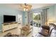 Well-lit living room with tile floors, ceiling fan, sliding glass doors and an adjacent bedroom at 5801 Oyster Catcher Dr. # 1614, North Myrtle Beach, SC 29582