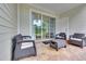 Inviting covered patio featuring comfortable wicker furniture and a sliding glass door at 5801 Oyster Catcher Dr. # 1614, North Myrtle Beach, SC 29582