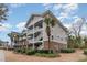 Exterior of a multi-story condominium building with brick and siding and palm trees in front at 5801 Oyster Catcher Dr. # 724, North Myrtle Beach, SC 29582