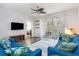 Living room with a blue sofa, a sliding glass door to a screened porch, and a television at 5801 Oyster Catcher Dr. # 724, North Myrtle Beach, SC 29582
