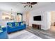 Living room with blue sofas, gray rug, TV, and view to the kitchen at 5801 Oyster Catcher Dr. # 724, North Myrtle Beach, SC 29582