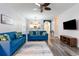 Living room with blue sofas, gray rug, TV, and view to the kitchen and dining room at 5801 Oyster Catcher Dr. # 724, North Myrtle Beach, SC 29582