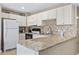 Kitchen with white appliances and mosaic tile backsplash with long counter at 5905 S Kings Hwy. # 318B, Myrtle Beach, SC 29575