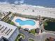 Aerial shot of a kidney-shaped pool surrounded by lounge chairs and the ocean at 5905 S Kings Hwy. # 318B, Myrtle Beach, SC 29575
