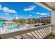 Balcony overlooking community pool with palm trees and the ocean in the distance at 625 N Waccamaw Dr. # 102, Murrells Inlet, SC 29576