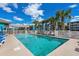 Community pool surrounded by palm trees, lounge chairs, and white picket fence at 625 N Waccamaw Dr. # 102, Murrells Inlet, SC 29576