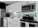 Updated kitchen boasts stainless steel microwave and oven with white cabinets at 625 N Waccamaw Dr. # 102, Murrells Inlet, SC 29576
