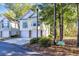 View of the home's exterior showcasing the driveway, two-car garage, and surrounding trees at 670 2Nd Ave. N, North Myrtle Beach, SC 29582