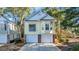 Charming two-story home with a two-car garage and light yellow siding surrounded by mature trees at 670 2Nd Ave. N, North Myrtle Beach, SC 29582