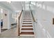 Inviting staircase with wood treads and white risers leads to upper level with light blue wall, white trim, and open floorplan at 670 2Nd Ave. N, North Myrtle Beach, SC 29582