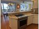 Well-lit kitchen with stainless steel stove, light countertops, and an open view to the dining area and beach view at 671 Norris Dr., Pawleys Island, SC 29585