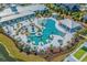 Aerial view of the community pool area, featuring cabanas, lounge chairs, palm trees, and a unique pool design at 6892 Belancino Blvd., Myrtle Beach, SC 29572