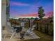Cozy backyard patio with a fire pit and Adirondack chairs, offering a serene view of the surrounding landscape and sunset at 6892 Belancino Blvd., Myrtle Beach, SC 29572