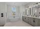 Bright bathroom with soaking tub, double vanity with gray cabinets, and elegant fixtures at 6892 Belancino Blvd., Myrtle Beach, SC 29572