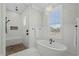 Bright bathroom with soaking tub, walk-in shower, and elegant chandelier lighting at 6892 Belancino Blvd., Myrtle Beach, SC 29572