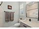 Neutral-toned bathroom with tiled shower, granite vanity and large mirror at 6892 Belancino Blvd., Myrtle Beach, SC 29572