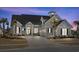 Charming two-story home with a well-manicured lawn, palm trees, and a welcoming entrance at twilight at 6892 Belancino Blvd., Myrtle Beach, SC 29572