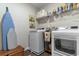 Bright laundry room featuring a washer, dryer, shelving, and an ironing board at 706 Gryffindor Dr., Little River, SC 29566