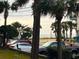 Distant view of the beach over cars and through trees and palm fronds at 7200 N Ocean Blvd. # 136, Myrtle Beach, SC 29572
