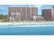 Expansive beachfront view of a tall condo building overlooking beach with many residents enjoying the ocean and sand at 7200 N Ocean Blvd. # 136, Myrtle Beach, SC 29572